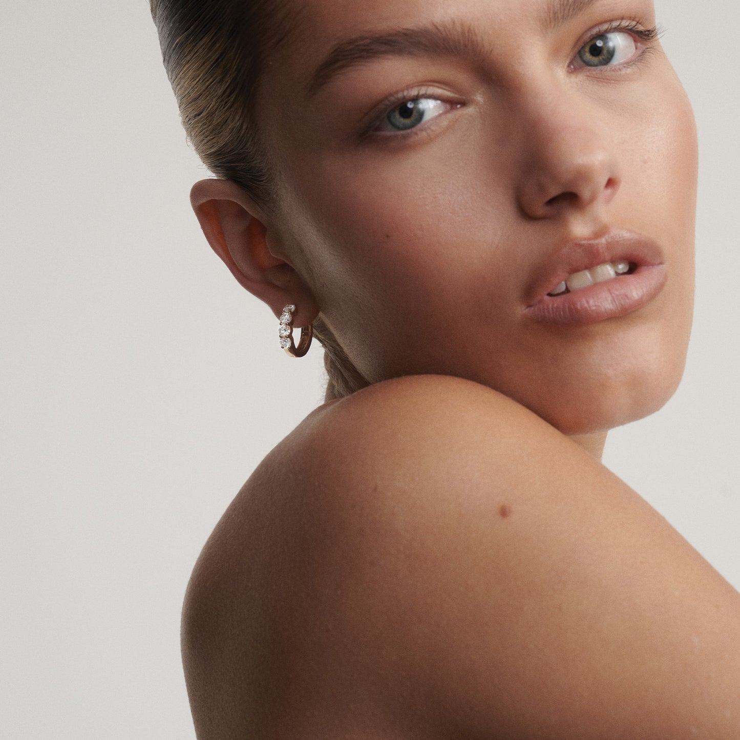 [text overlay: Faith wears our Bold Diamond Huggies in yellow gold]