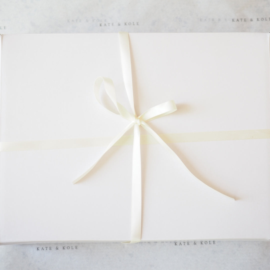 White gift box with a gold ribbon on a white background