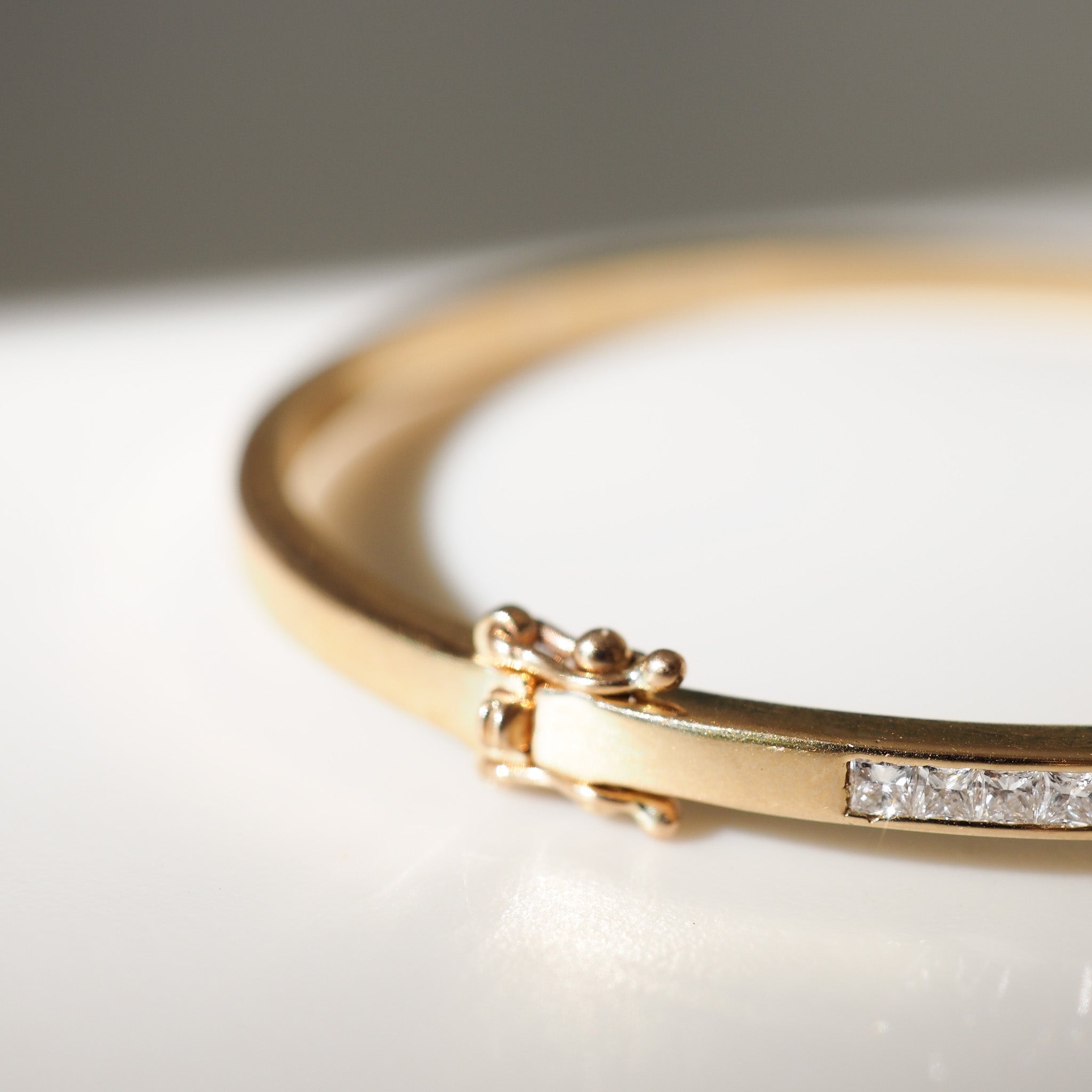Gold bracelet with diamond accents on a white surface