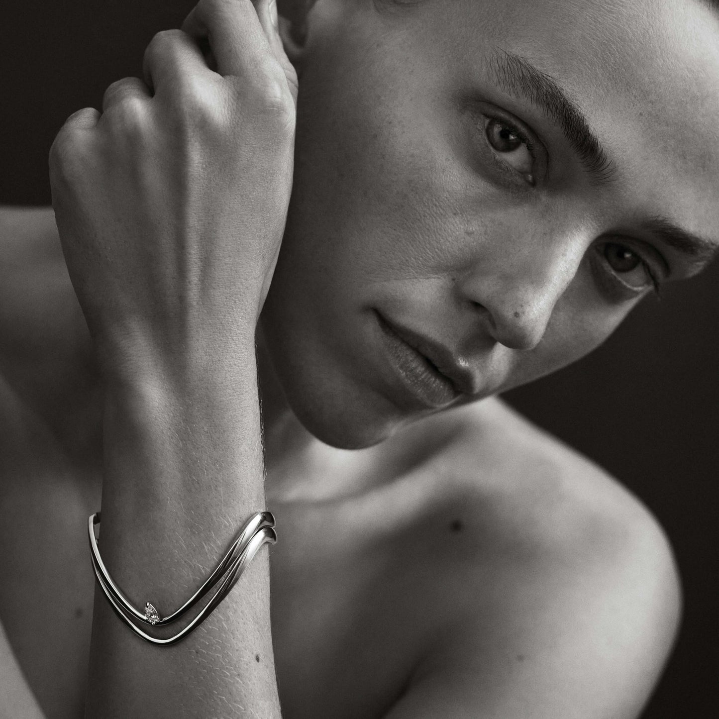 Black and white close-up of a person wearing a bracelet.