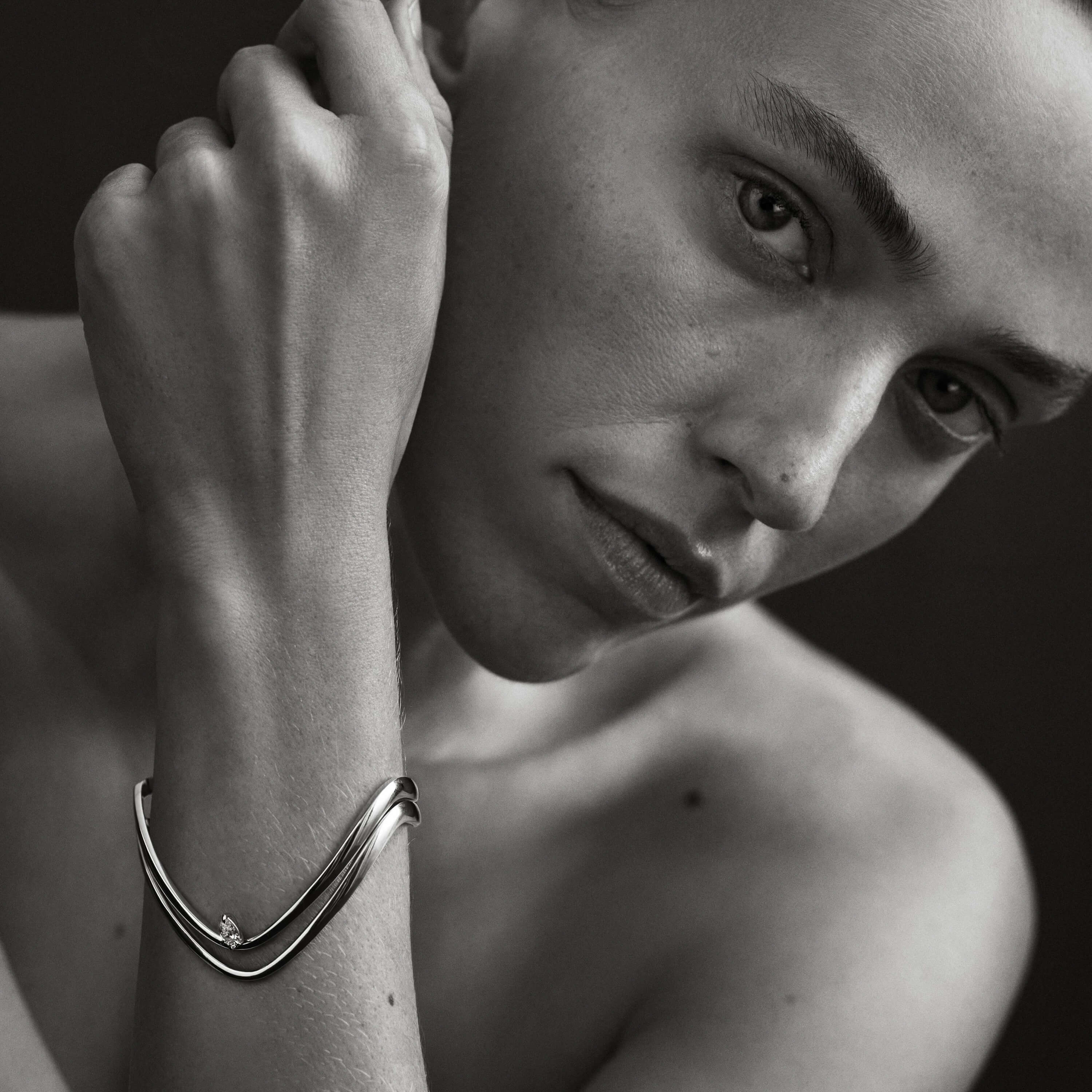 Black and white close-up of a person wearing a bracelet.