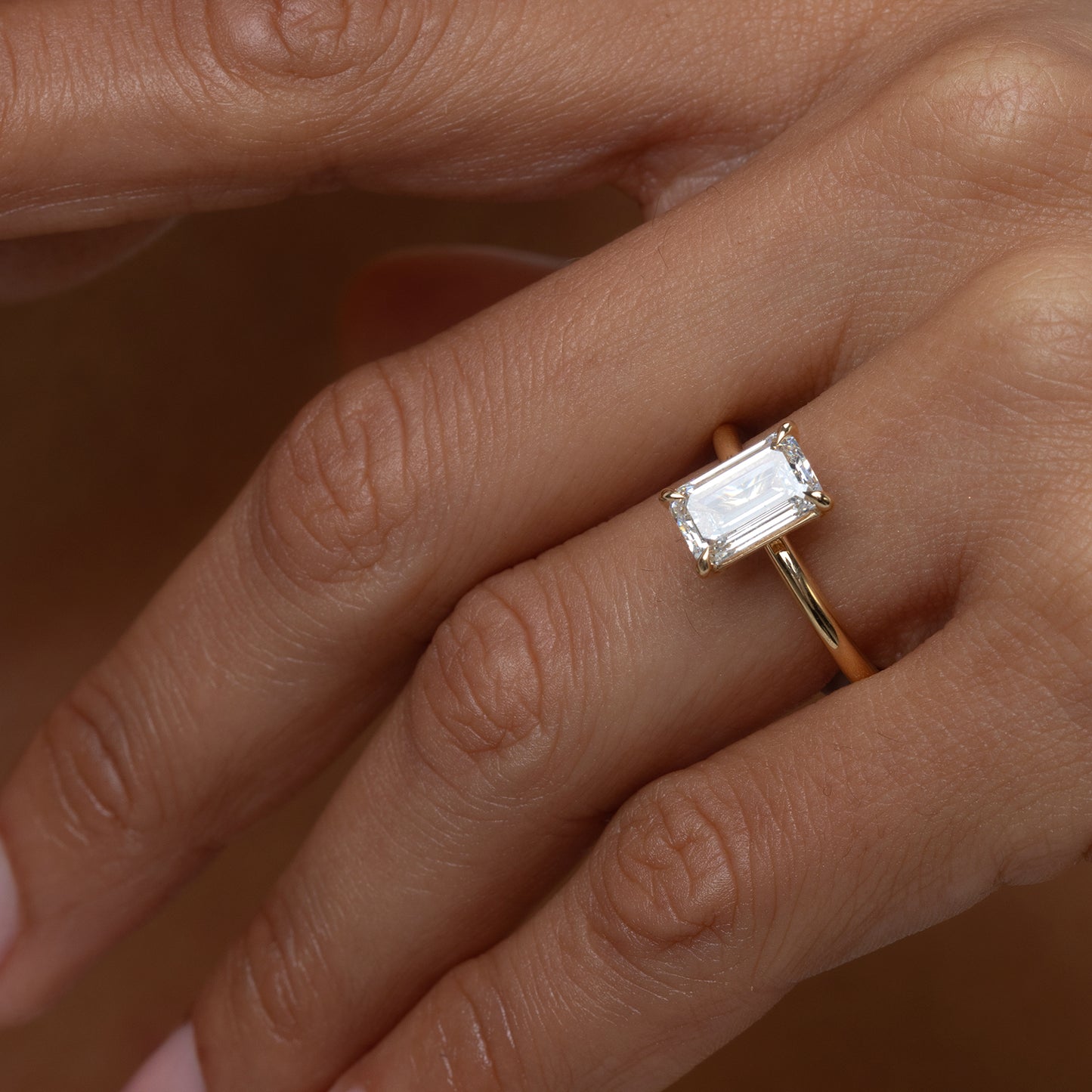 Gold ring with a diamond on a person's finger