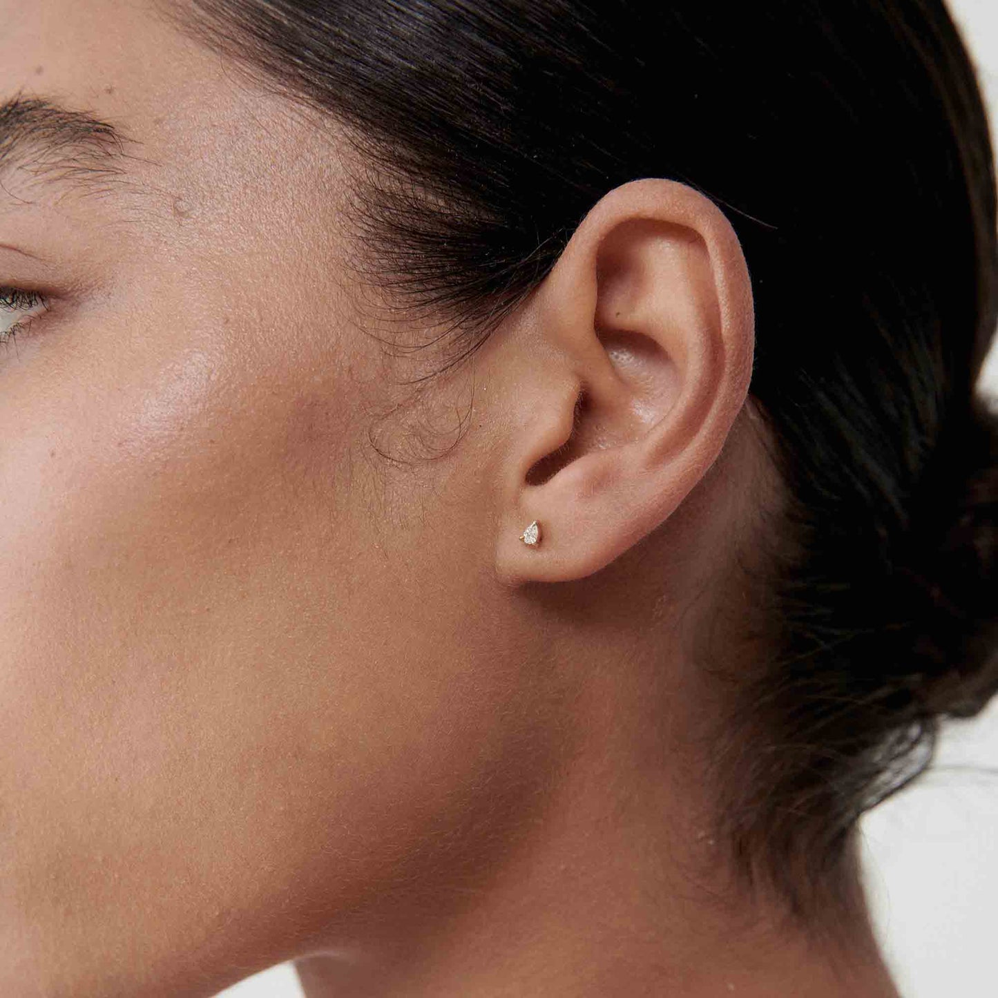 Profile of a person wearing a small, elegant diamond stud earring, showcasing minimalist luxury jewellery.