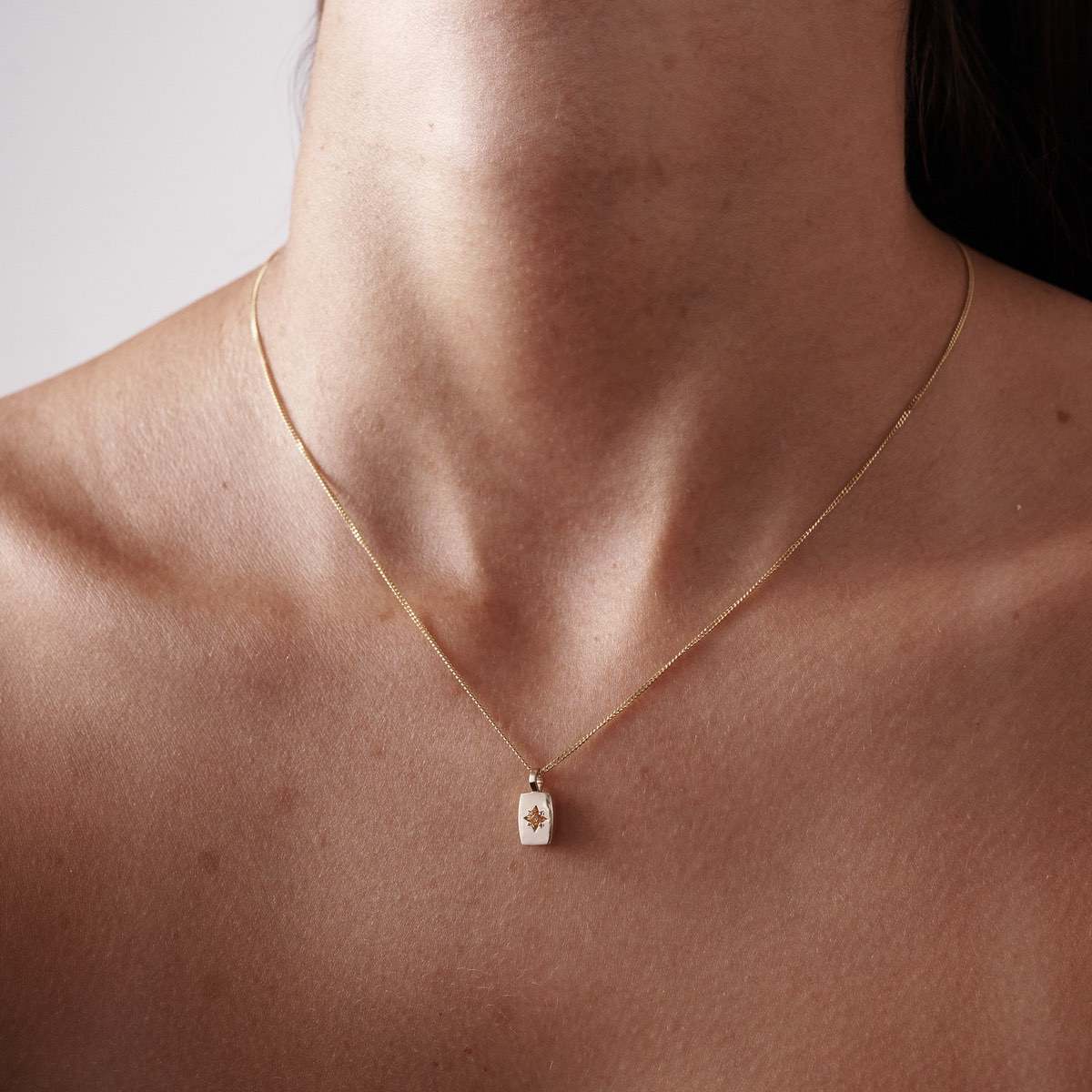 Model wearing Solid Yellow Gold Archetype Necklace Petite Rectangle Pendant with Star Set Yellow Sapphire on a 45cm Diamond Curb Chain 