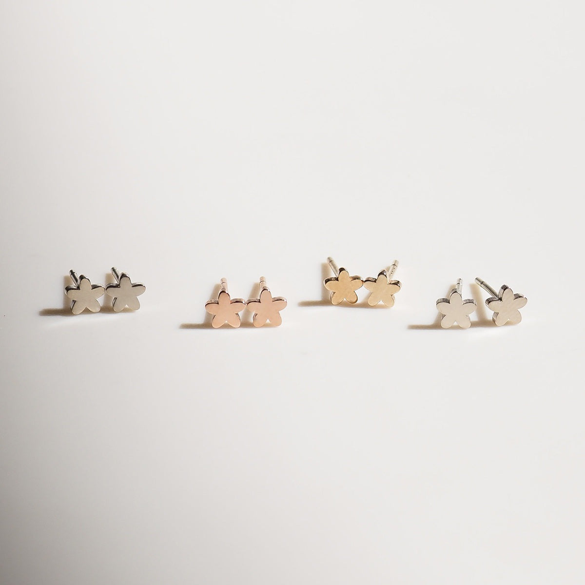 A variety of Flower studs on a beige background