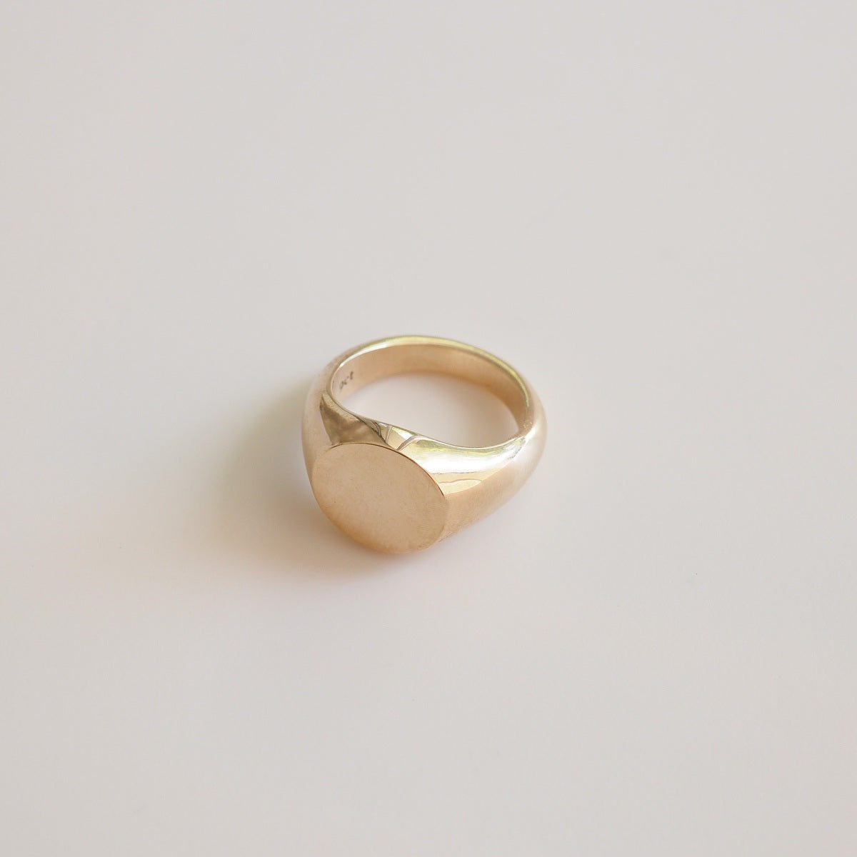 Gold ring on a light beige background