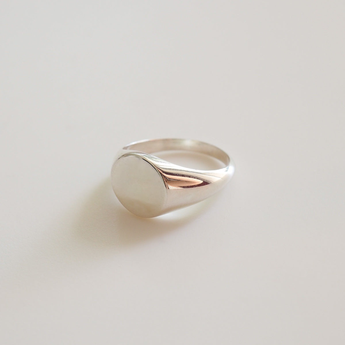 Silver ring on a light gray background