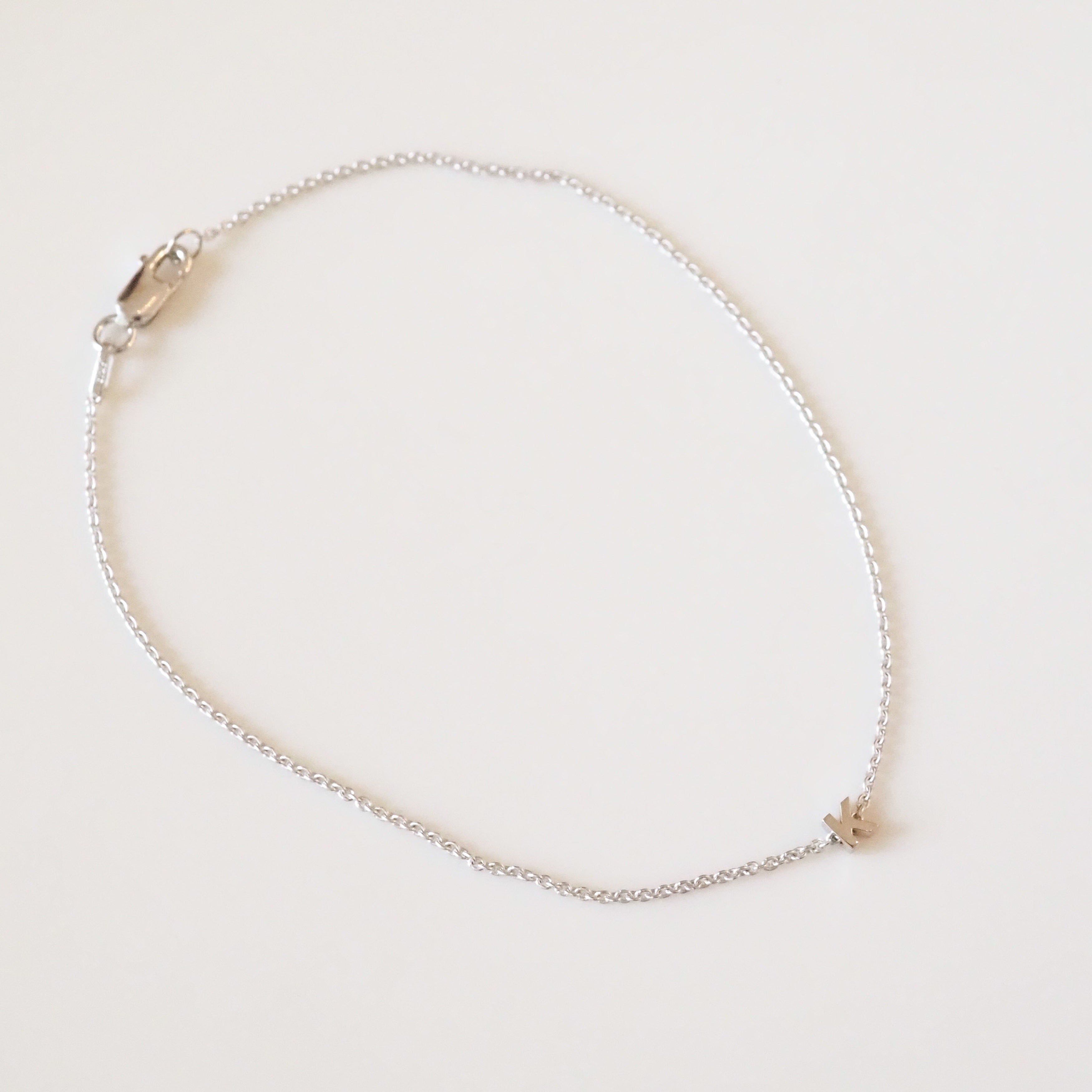 Delicate silver necklace on a light beige background