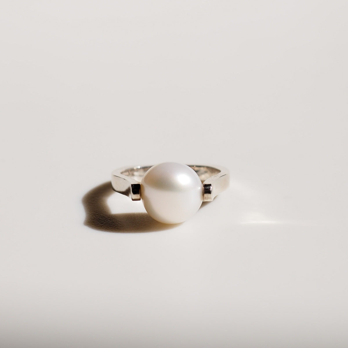 a single silver Baroque Pearl Ring on cream background