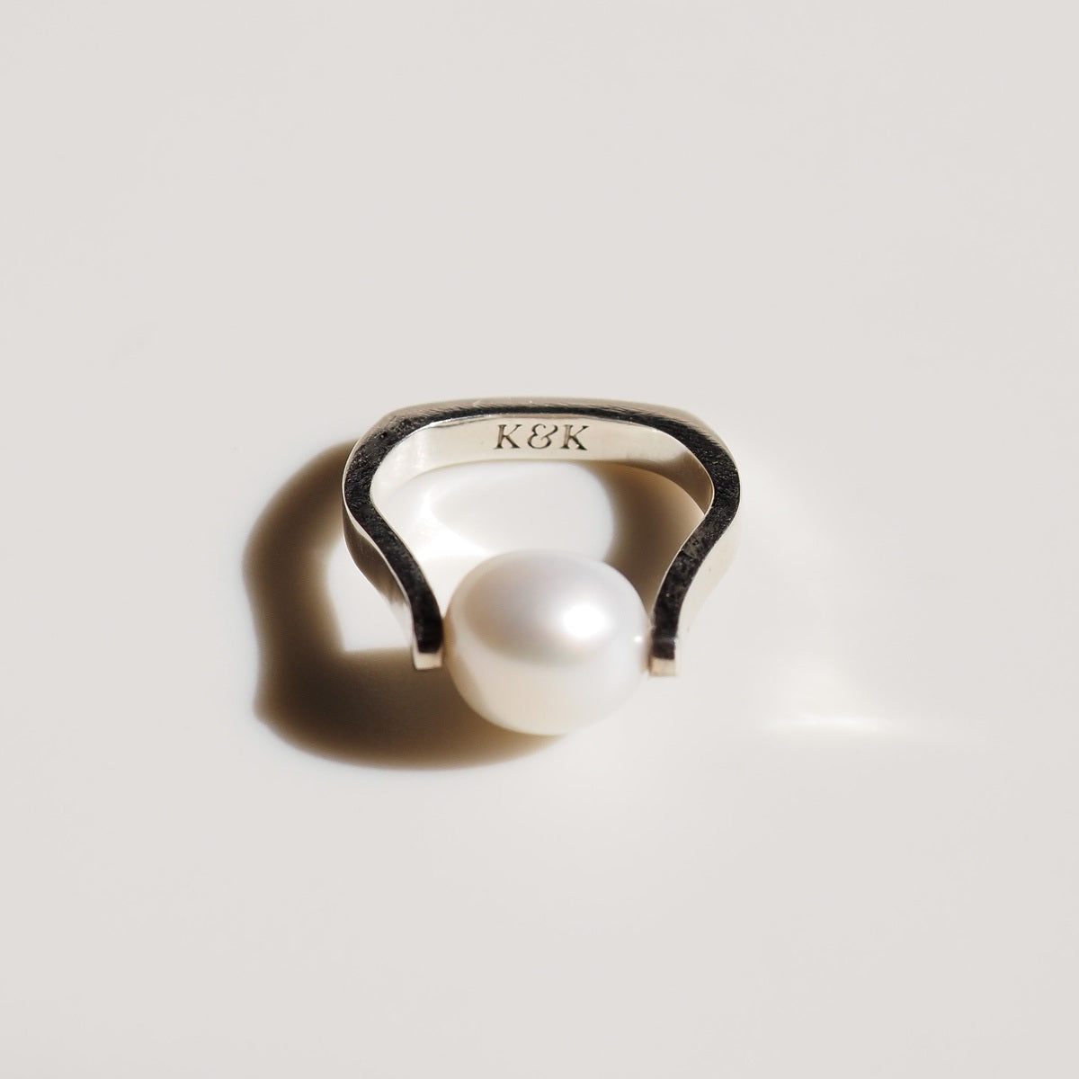 a single silver Baroque Pearl Ring on cream background