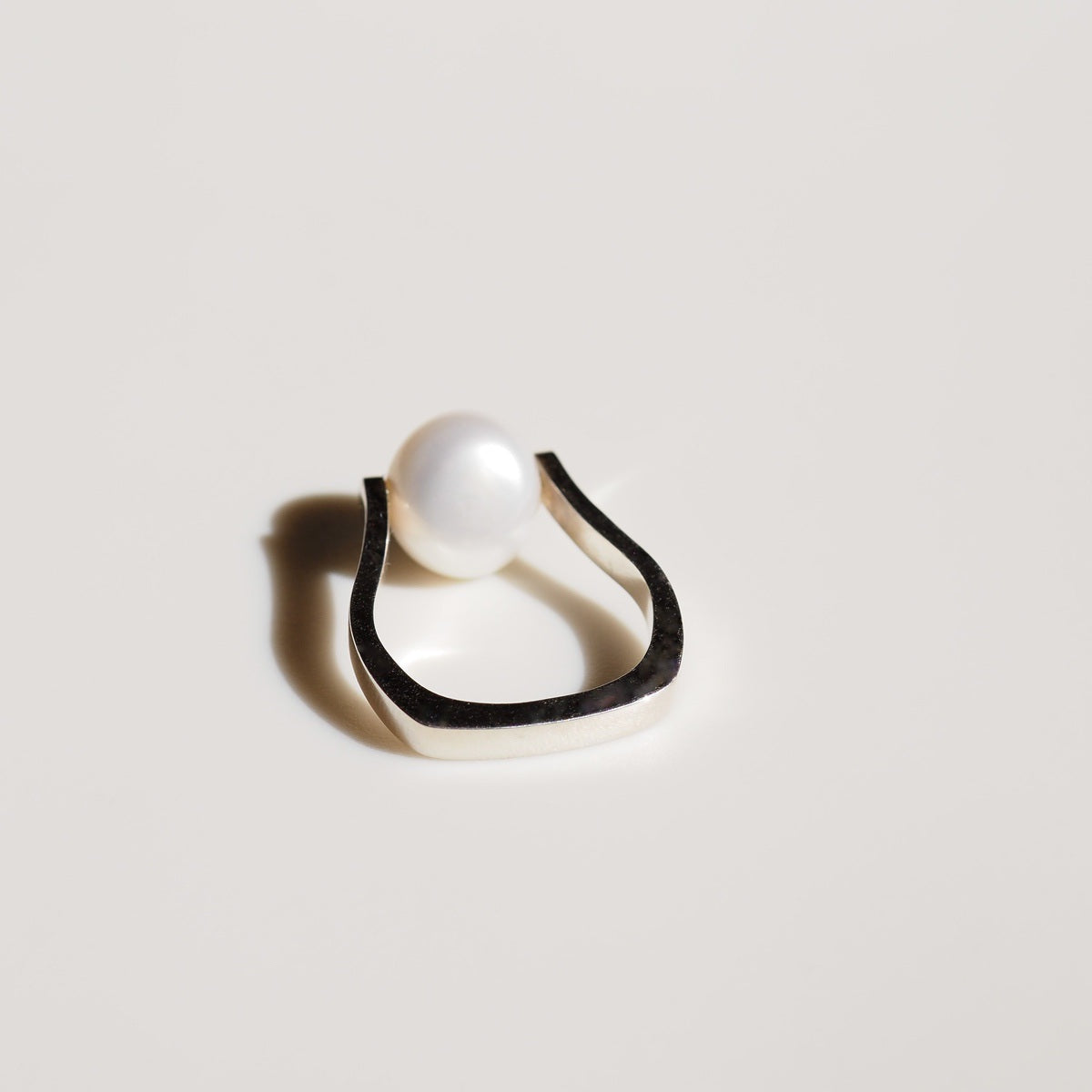 a single silver Baroque Pearl Ring on cream background