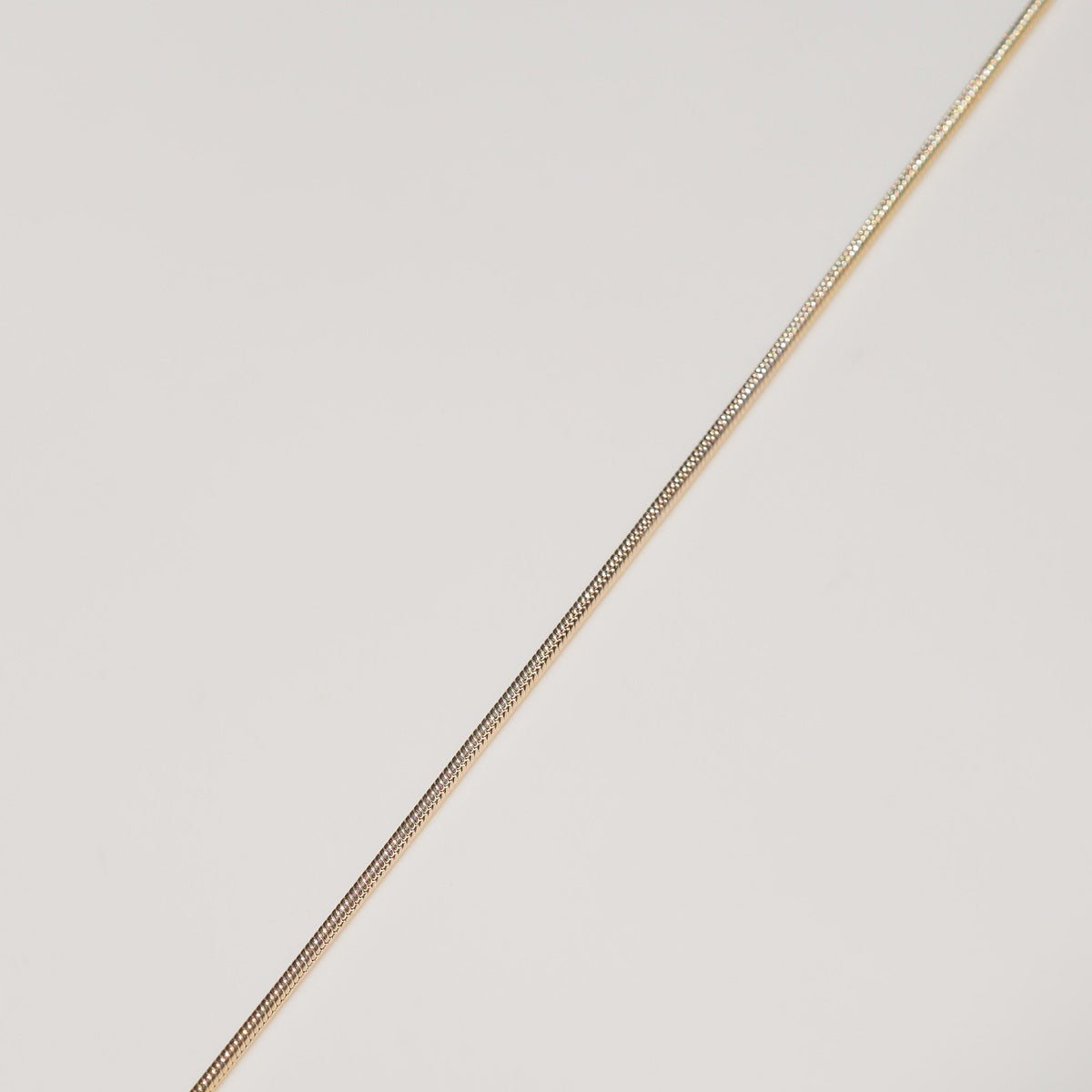 a flat lay of our Snake Chain Drops styled on a cream background