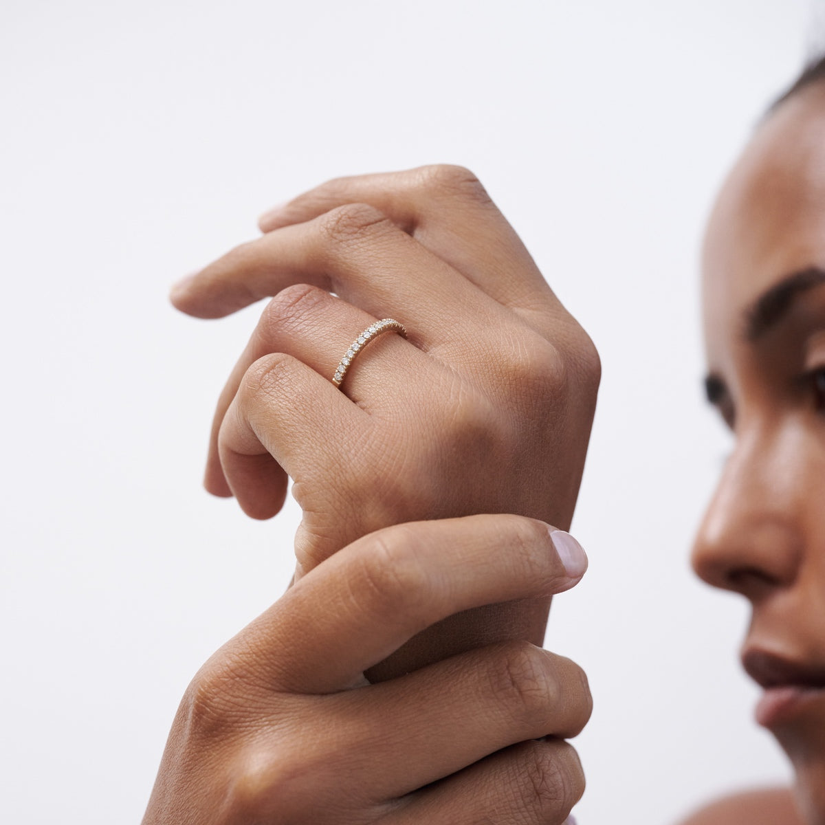 Model wearing 18ct yellow gold diamond Amaré wedding band on her wedding finger - band featuring half round diamonds 