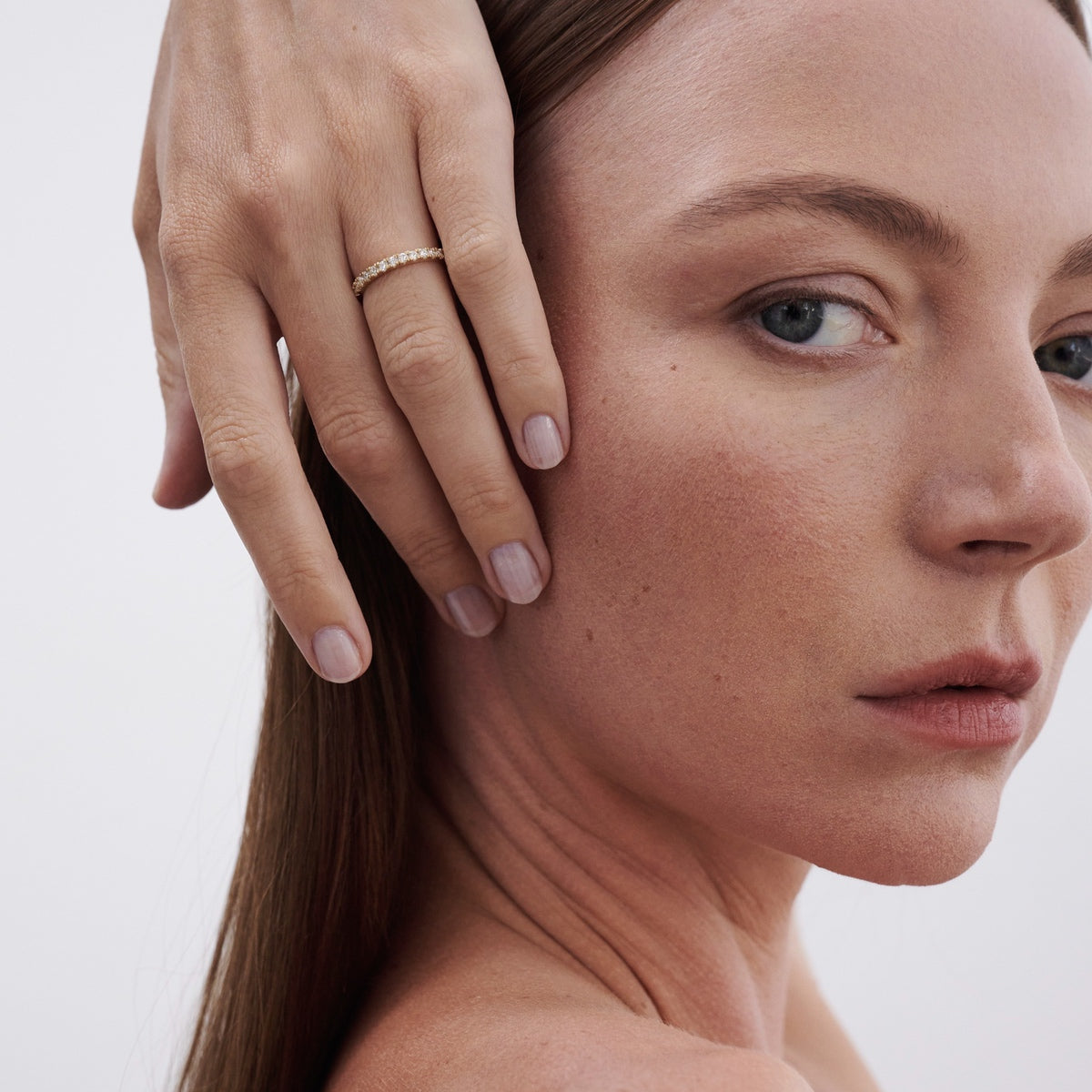 Model wearing diamond Amaré 1.4mm band with 12 diamonds that wrap around the band on wedding finger