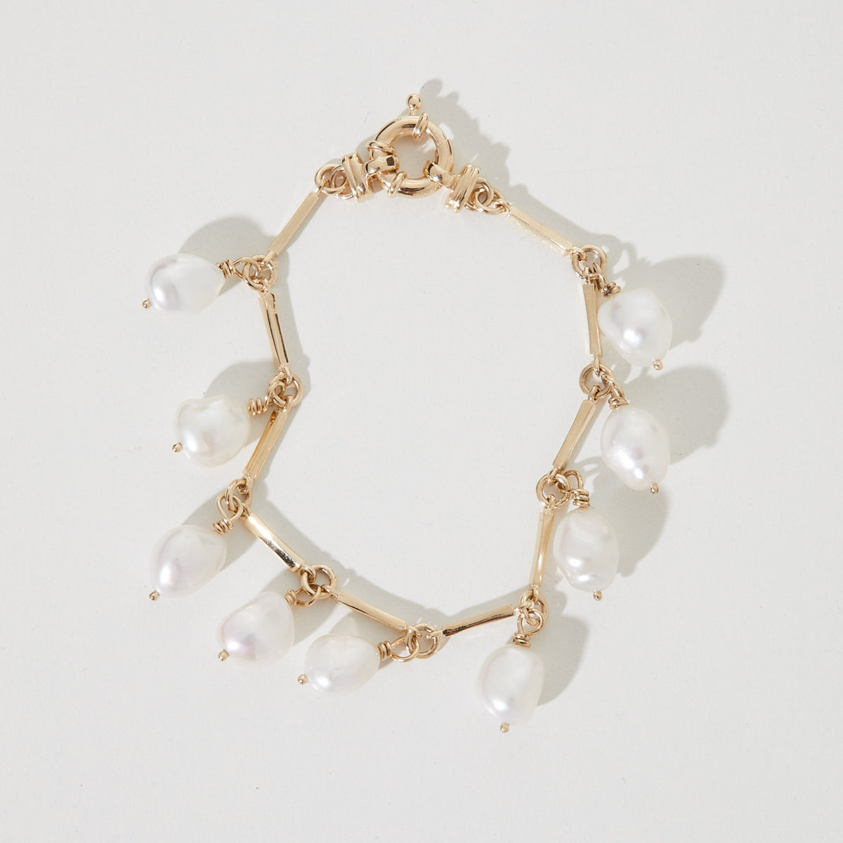 Hand-made Baroque Freshwater Pearl Jewellery: our beautiful 9ct yellow gold baroque pearl link bracelet with a fob closure, drenched in sunlight