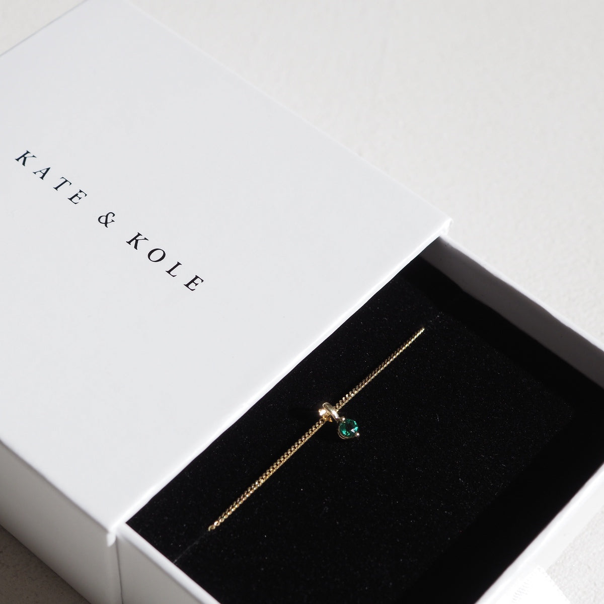 Our 9ct yellow gold birthstone necklace with an emerald stone on a 45cm diamond curb chain wrapped up in our Kate & Kole jewellery box