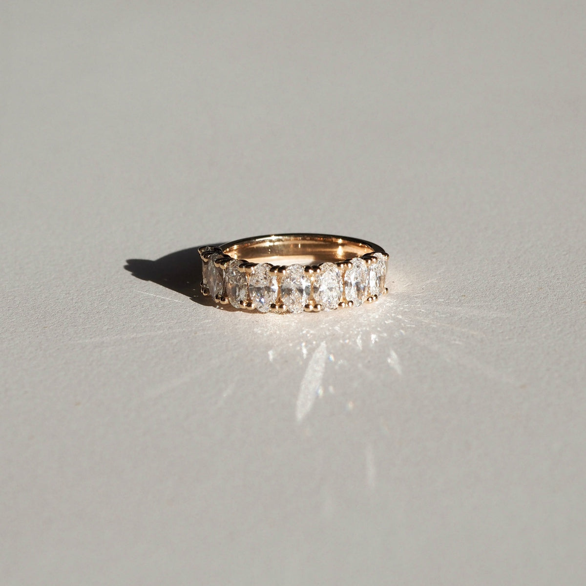 A half-infinity style ring, featuring an array of oval lab-grown diamonds that end and begin again — replicating the circular journey of true love. This piece is created with eight 5x3mm lab-grown oval cut diamonds, splayed along a round gold band. The total carat weight is approximately 1.60ct.