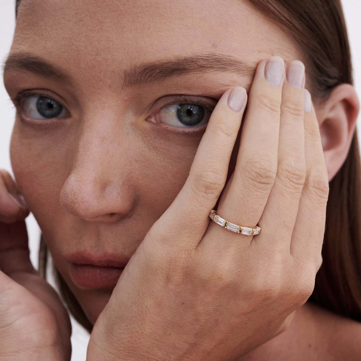 Celine is created with five emerald-cut lab-grown diamonds. The approximate total carat weight of this piece is 1.75ct. An elegant half-infinity row of five emerald cut lab-grown diamonds — secured seamlessly by solid gold bar settings.