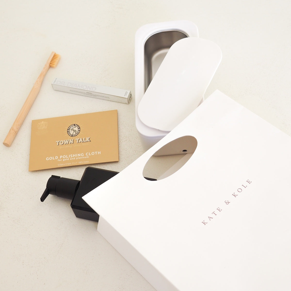 Collection of cleaning tools and products on a light surface with 'Kate & Kole' branding.