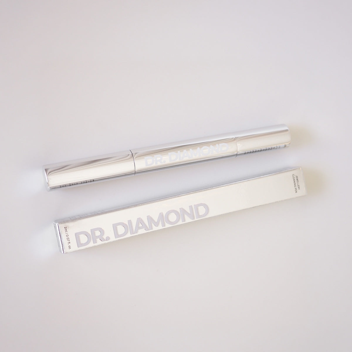 Two silver makeup brushes with 'Dr. Diamond' branding on a light gray background