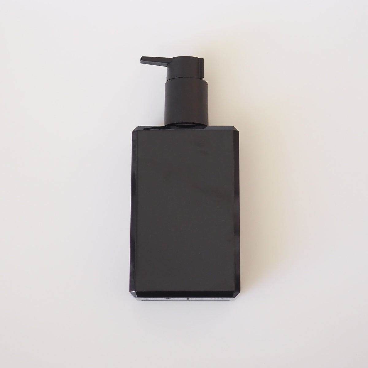 Black rectangular bottle with pump on a white background