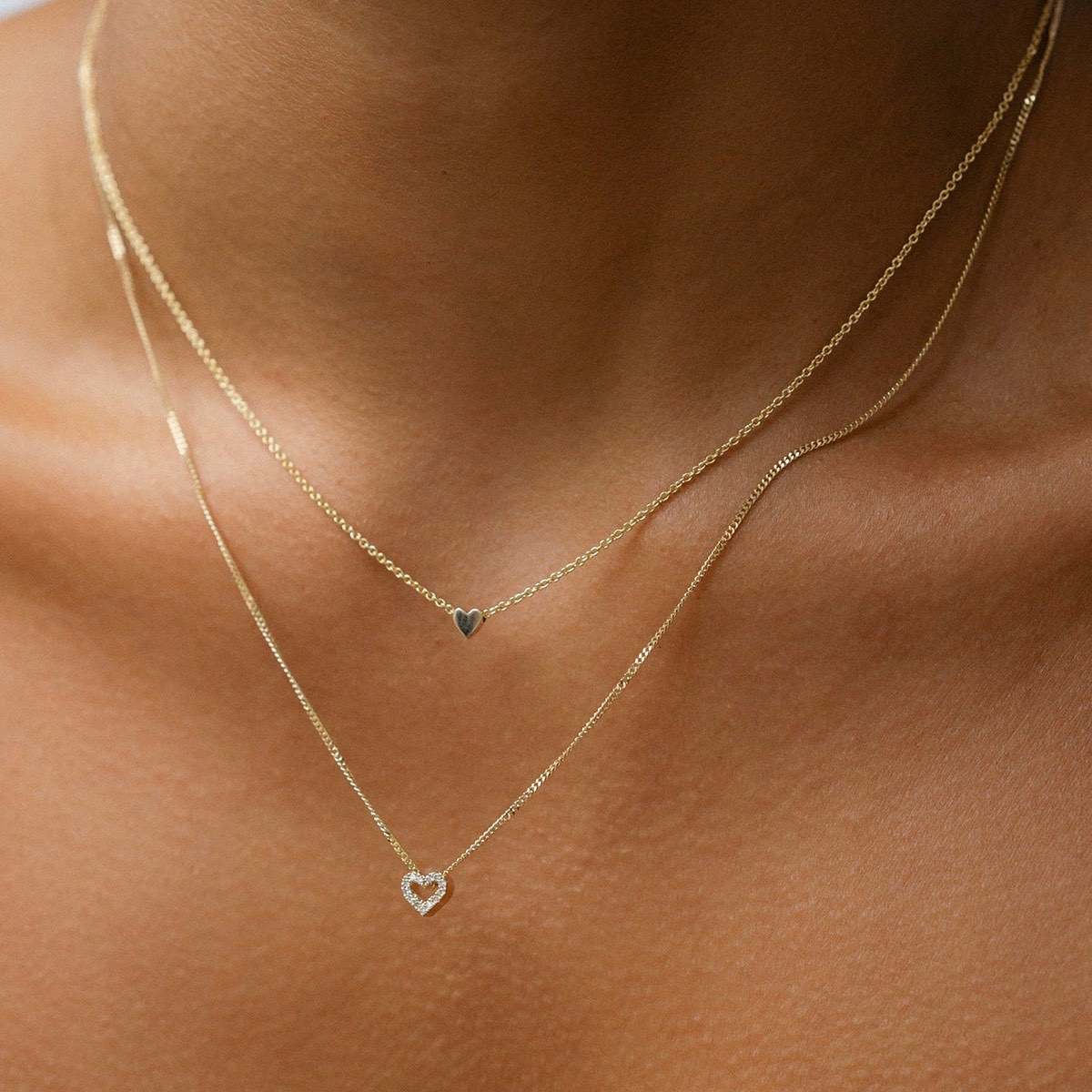 Model wears our beautiful Diamond Heart Charm Necklace in 9ct yellow gold, with a 45cm diamond curb chain layered with our 40cm solid gold Tiny Letter Necklace