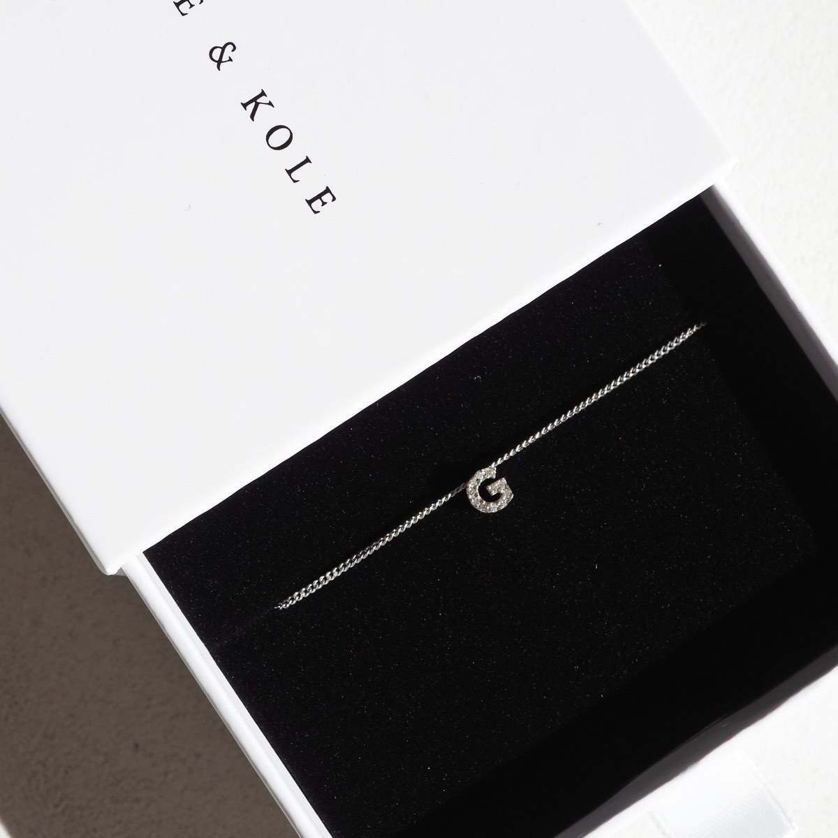 Diamond Letter Charm necklace sitting perfectly in a white Kate and Kole jewellery box