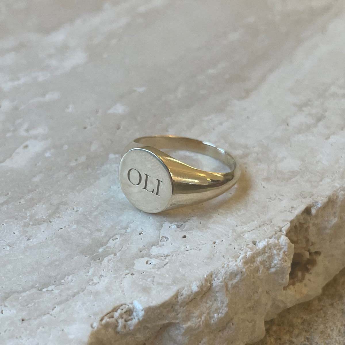 Round signet ring with OLI engraved on the face. Add a date, initials, images or words in a bespoke style to our customisable products. Choose from single letter (for tiny beads and charms) or multiple letters for dates and words.