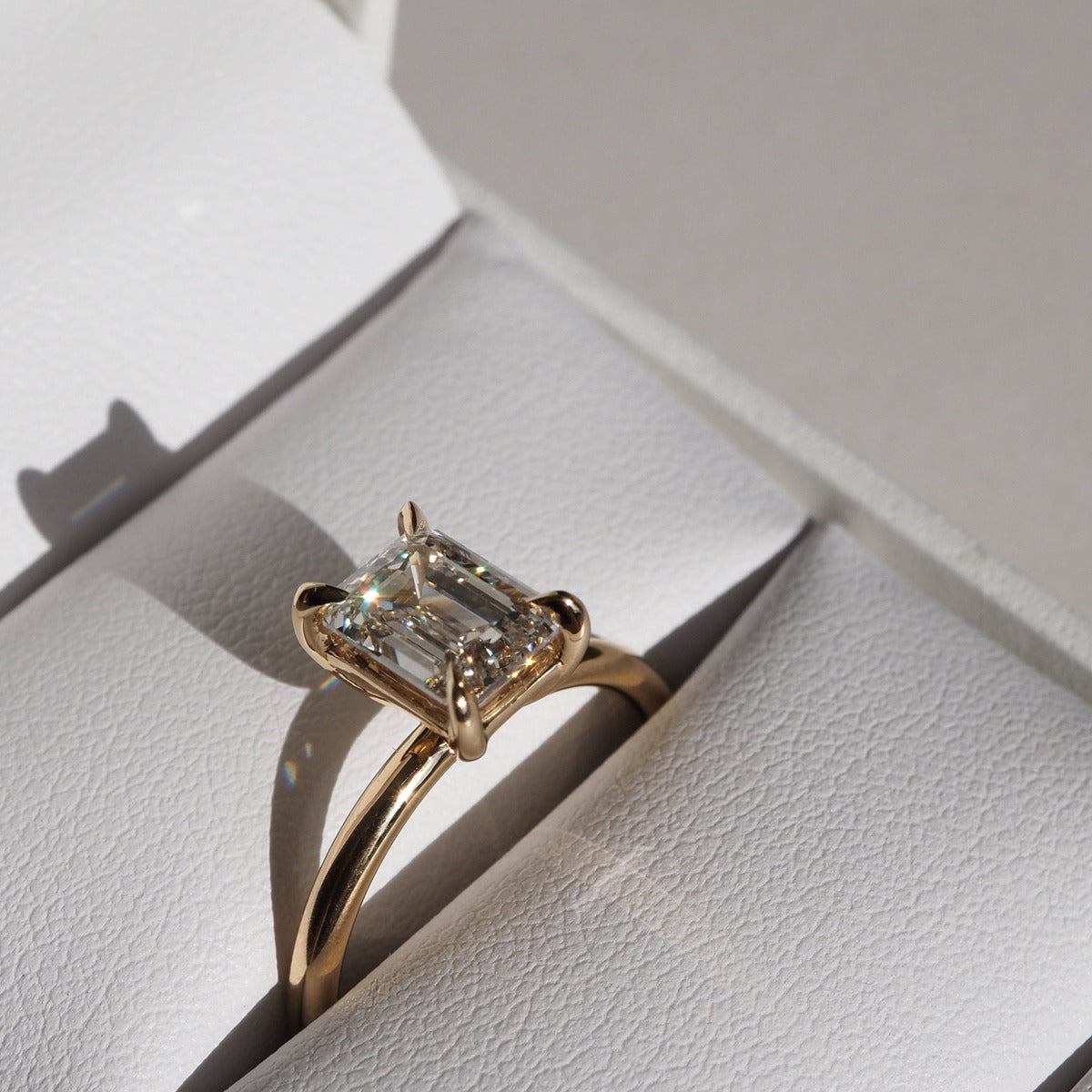 Simple, elegant and perfectly set. Eva features a beautiful emerald cut lab-grown diamond, held within a basket setting by four subtle talon claws. 18ct solid yellow gold 