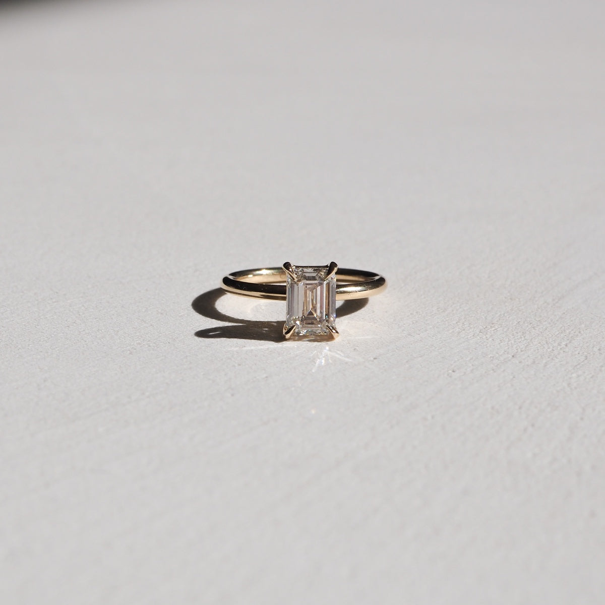Simple, elegant and perfectly set. Eva features a beautiful emerald cut lab-grown diamond, held within a basket setting by four subtle talon claws. 18ct solid yellow gold 