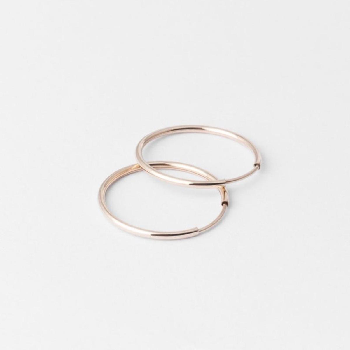 Solid Gold Everyday Hoops: Flat lay of high quality solid rose gold and silver stacker earrings