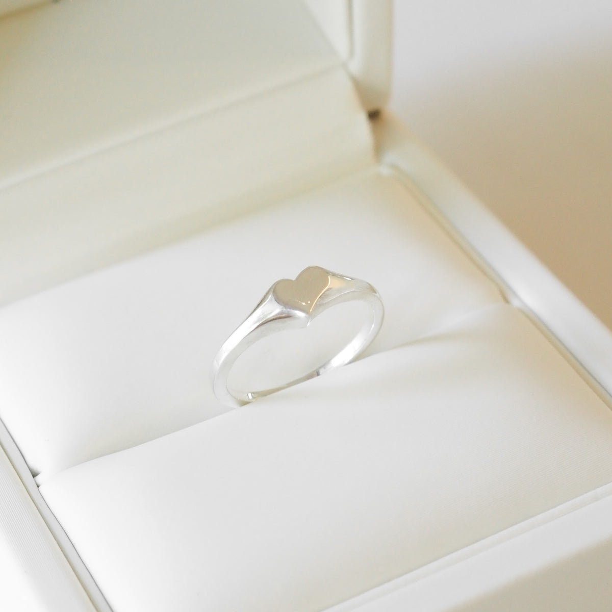 Silver ring in a jewelry box on a light background