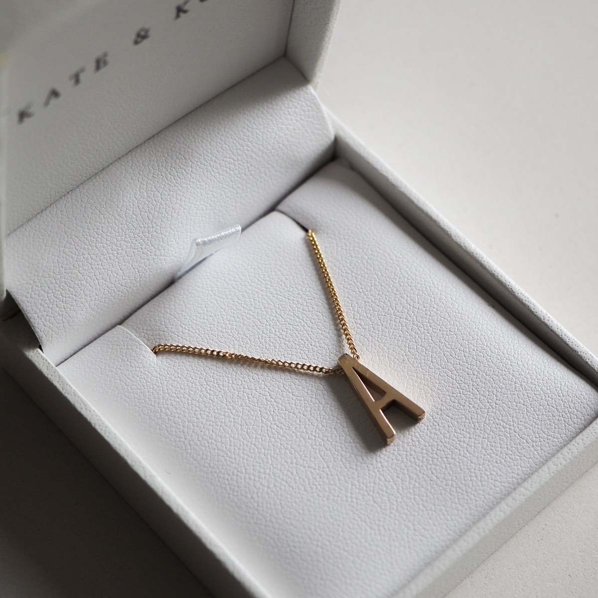 Gold letter "A" necklace in an elegant white jewellery box with a delicate chain, perfect for personalised luxury gifts.