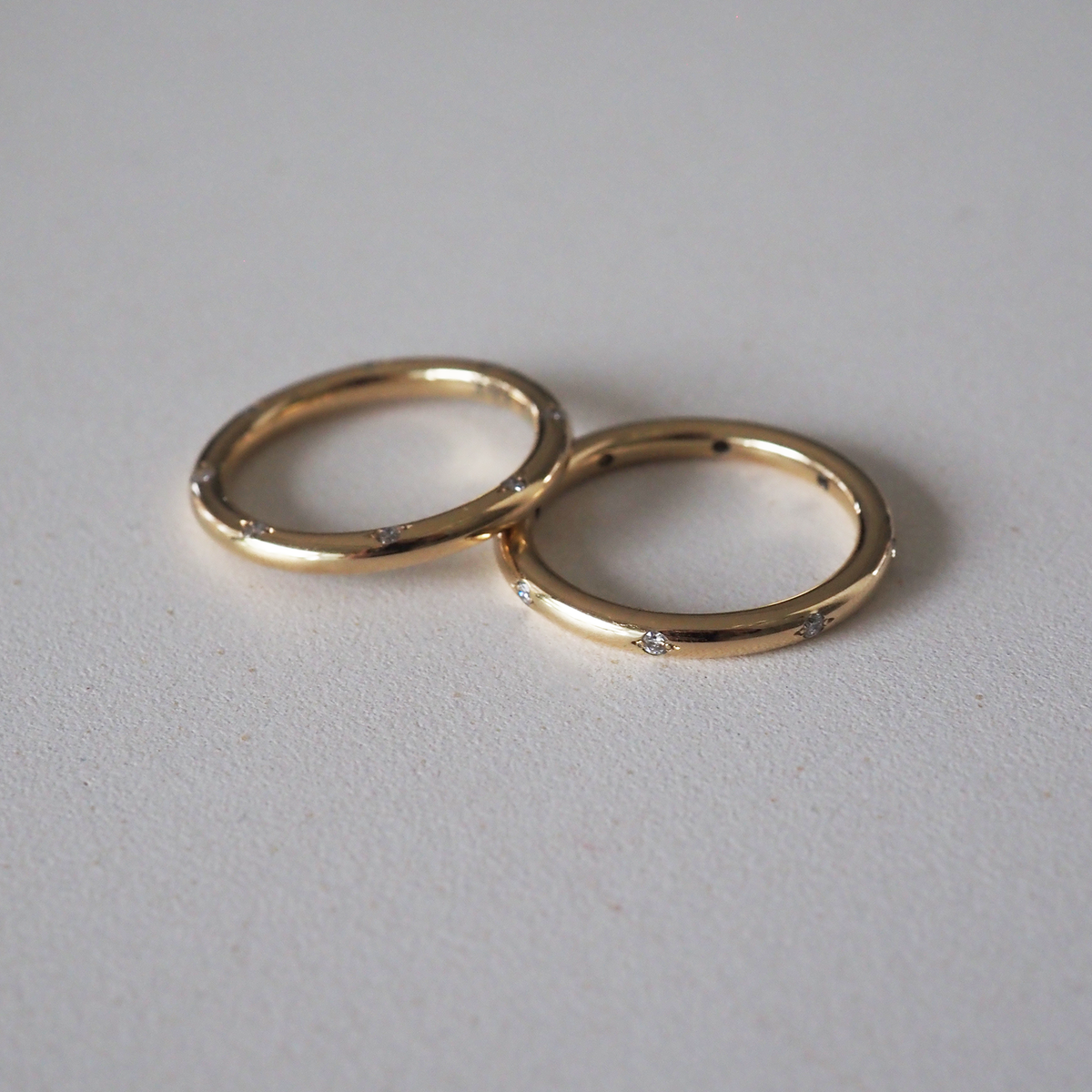 A solid gold round profile band for the modern minimalist — set with eight ornately set lab-grown diamonds spaced along the top or side edge.