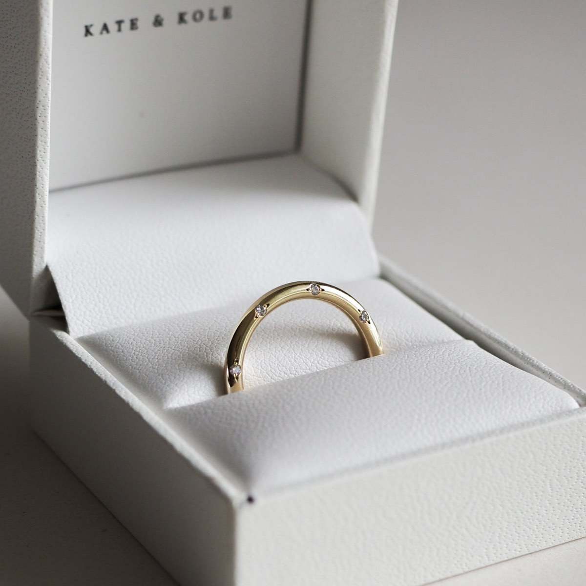 A solid gold round profile band for the modern minimalist — set with eight ornately set lab-grown diamonds spaced along the top or side edge.