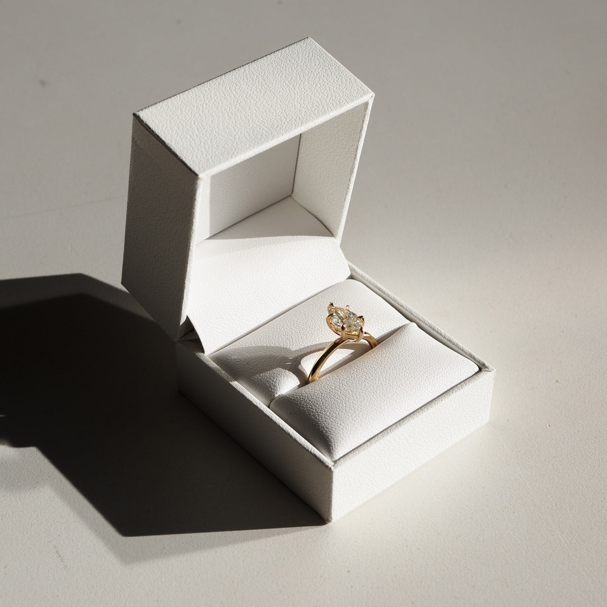 A mesmerising six claw solitaire engagement ring — showcasing the slender silhouette of a marquise cut lab-grown diamond - set in solid 18ct yellow gold.