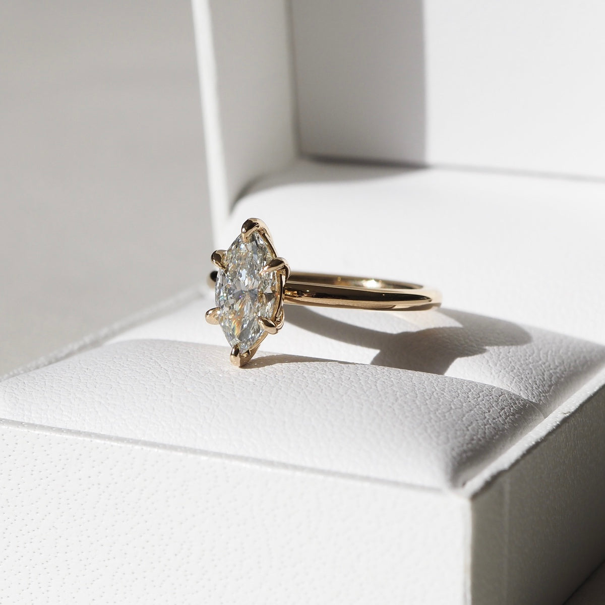 A mesmerising six claw solitaire engagement ring — showcasing the slender silhouette of a marquise cut lab-grown diamond - set in solid 18ct yellow gold. 