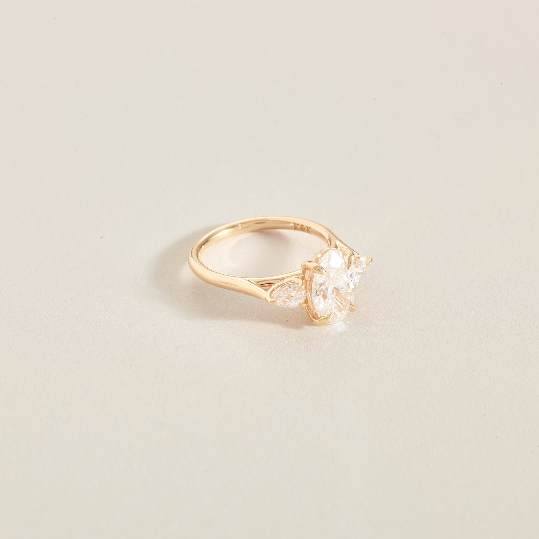 Gold ring with a 3 diamonds on a light beige background
