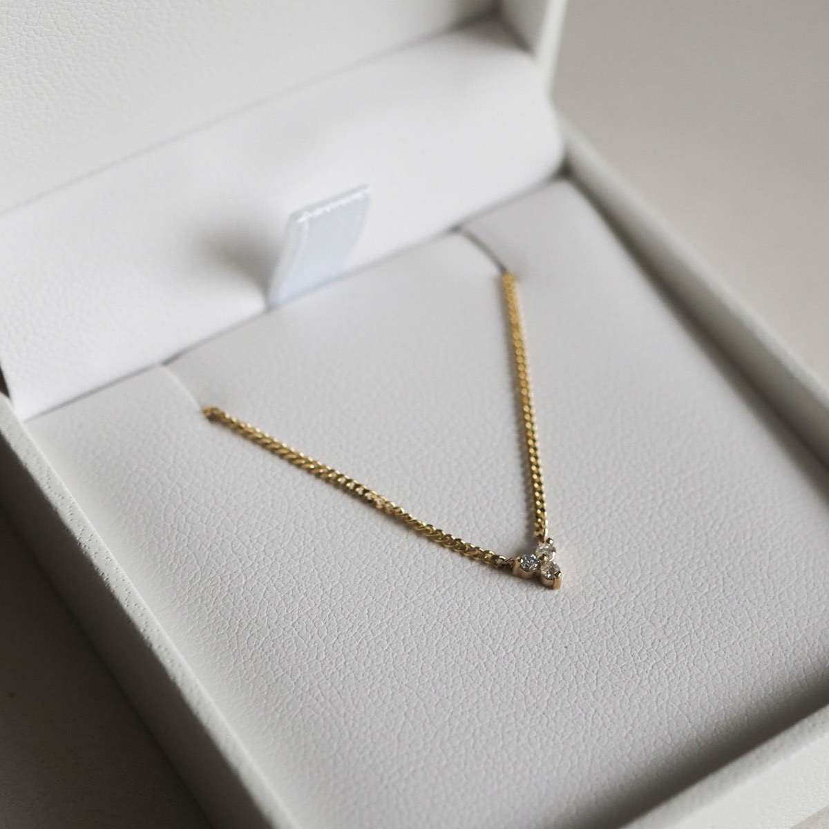 Our Solid Gold Therefore Trio Cluster Necklace laid flat in a Kate & Kole jewellery box