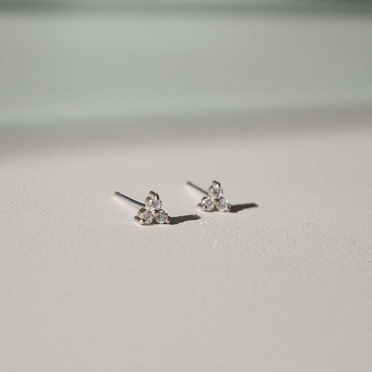 Flat lay of our Sterling Silver Therefore Studs made for everyday.[text overlay: Sterling silver setting]