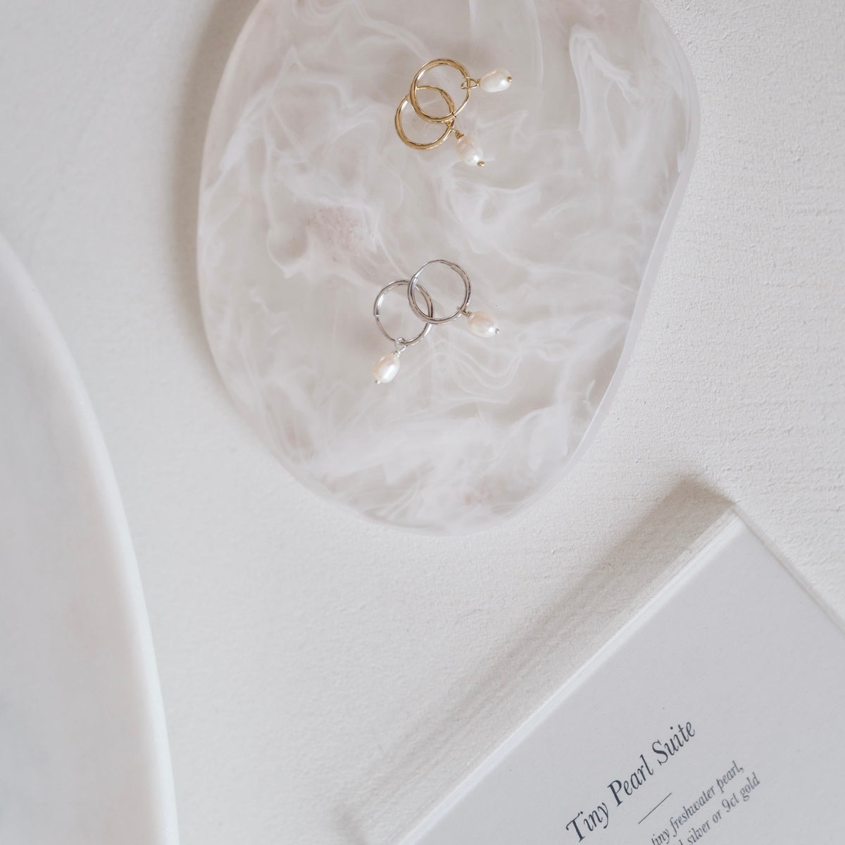 Freshwater Pearl Hoop Earrings: Flat lay of yellow gold and sterling silver hand wrapped pearl hoops.