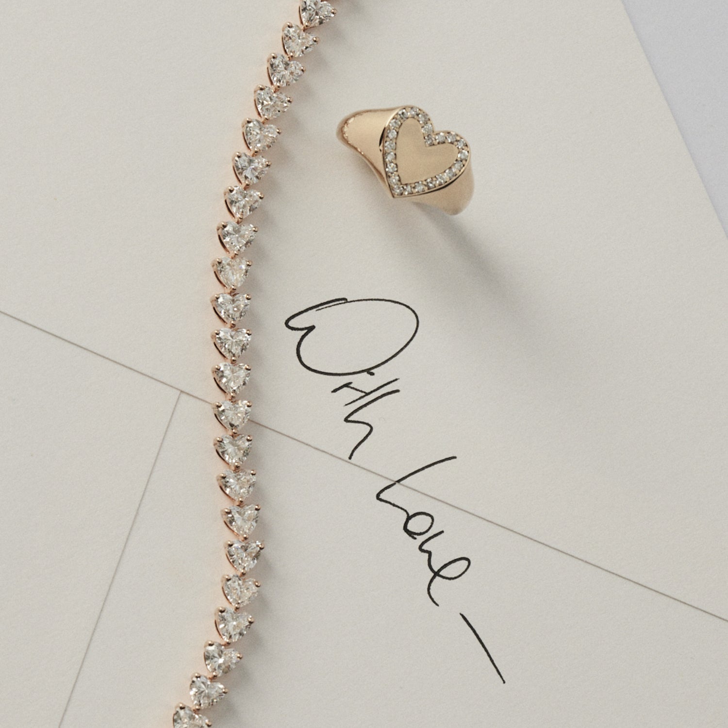 Heart-shaped signet and diamond bracelet on a light background with 'With Love' text.