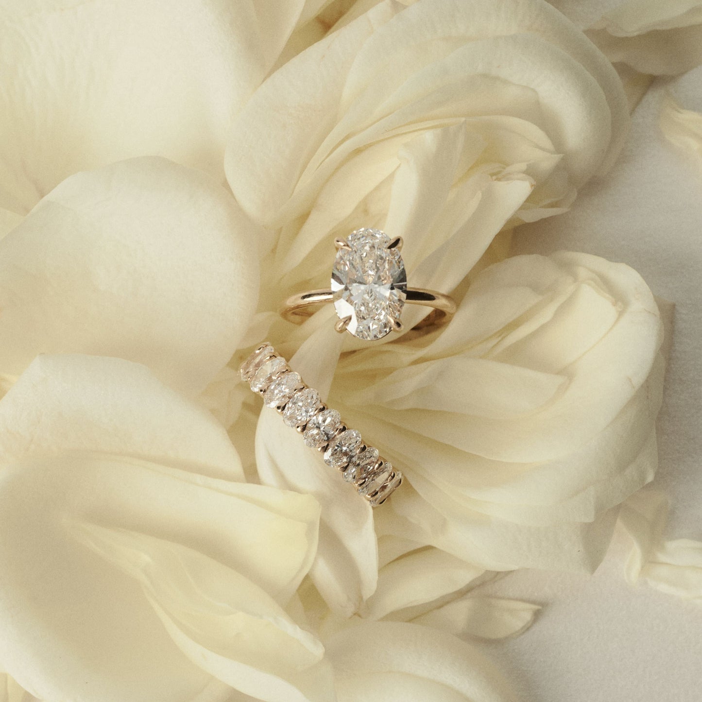 Diamond ring on a bed of white roses
[text overlay: 2ct Diamond and Camille Diamond Band]