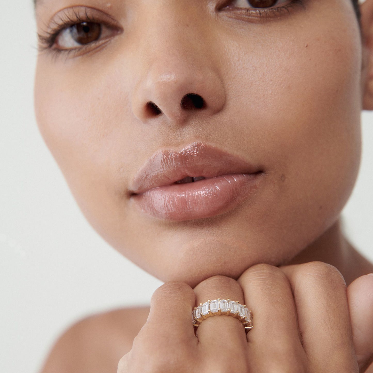 Close-up of a person wearing a luxurious diamond ring with baguette-cut stones, showcasing elegance and sophistication.