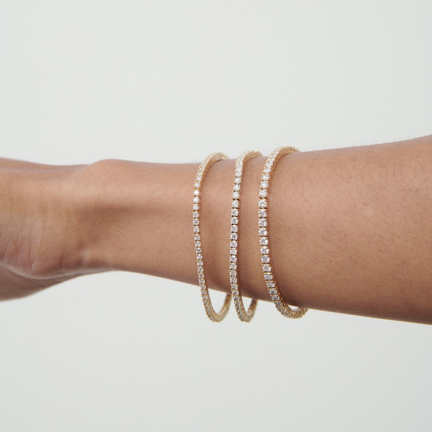 Elegant gold and diamond bangles on a wrist, showcasing luxury jewellery design.