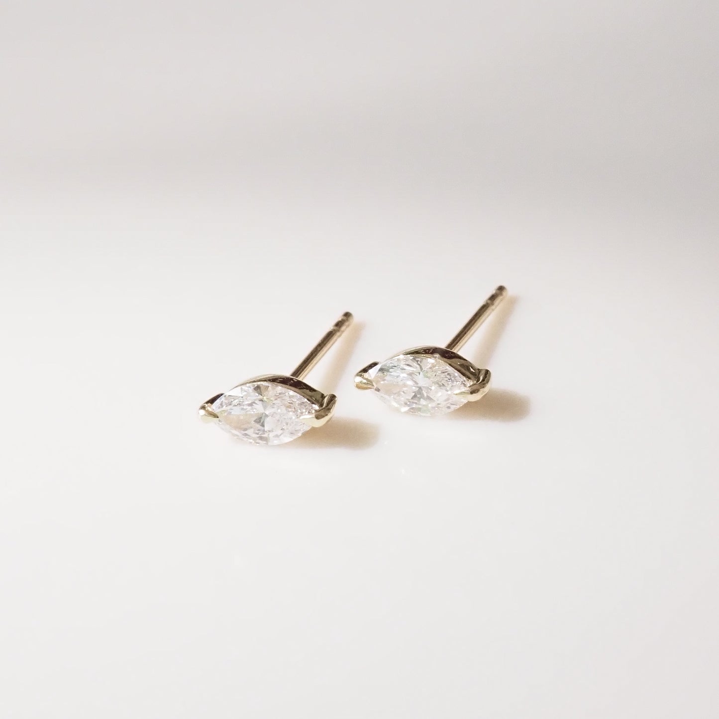 Pair of marquise diamond stud earrings on a light gray background