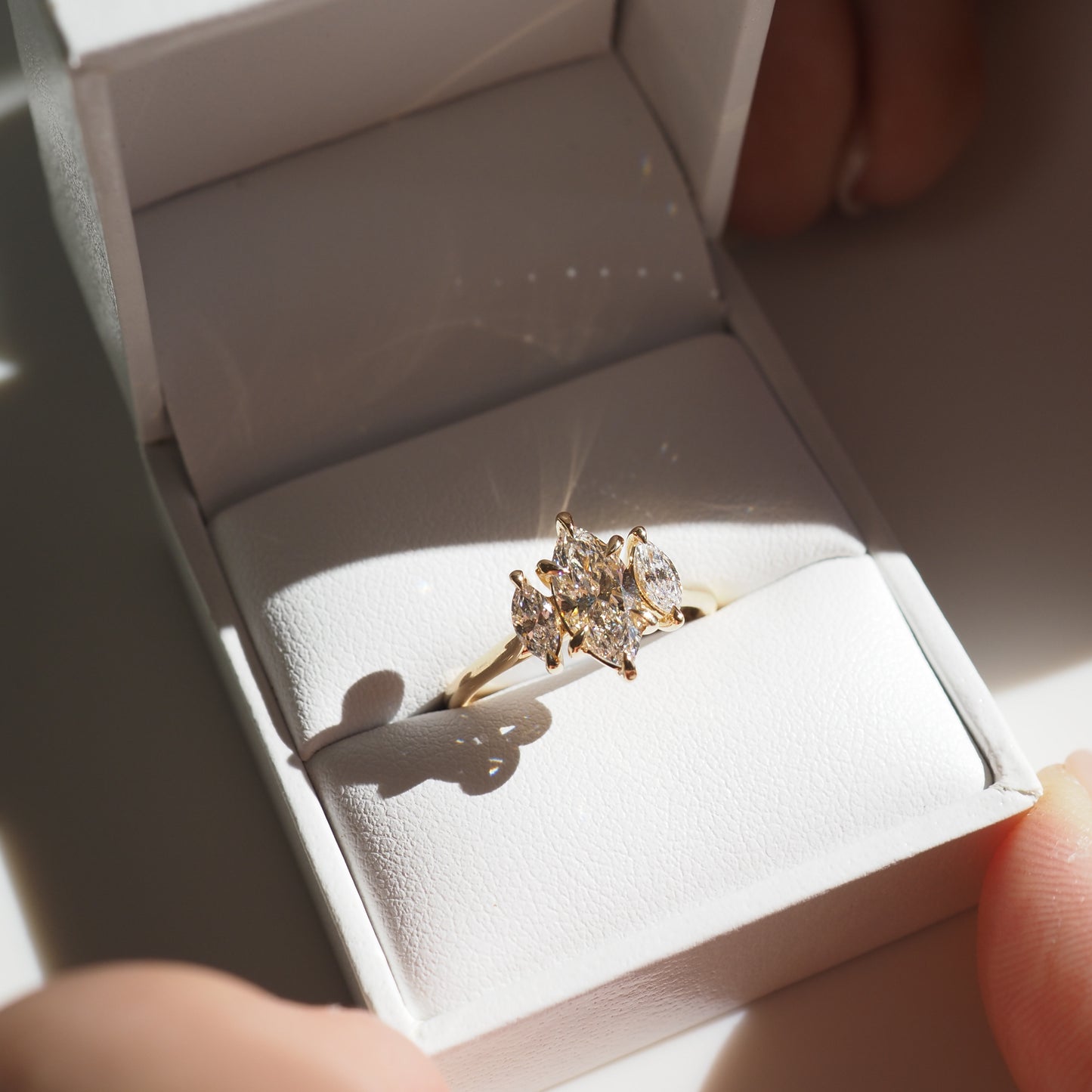 Luxurious marquise-cut diamond ring in an elegant white jewellery box, showcasing high-end craftsmanship and luxury design.