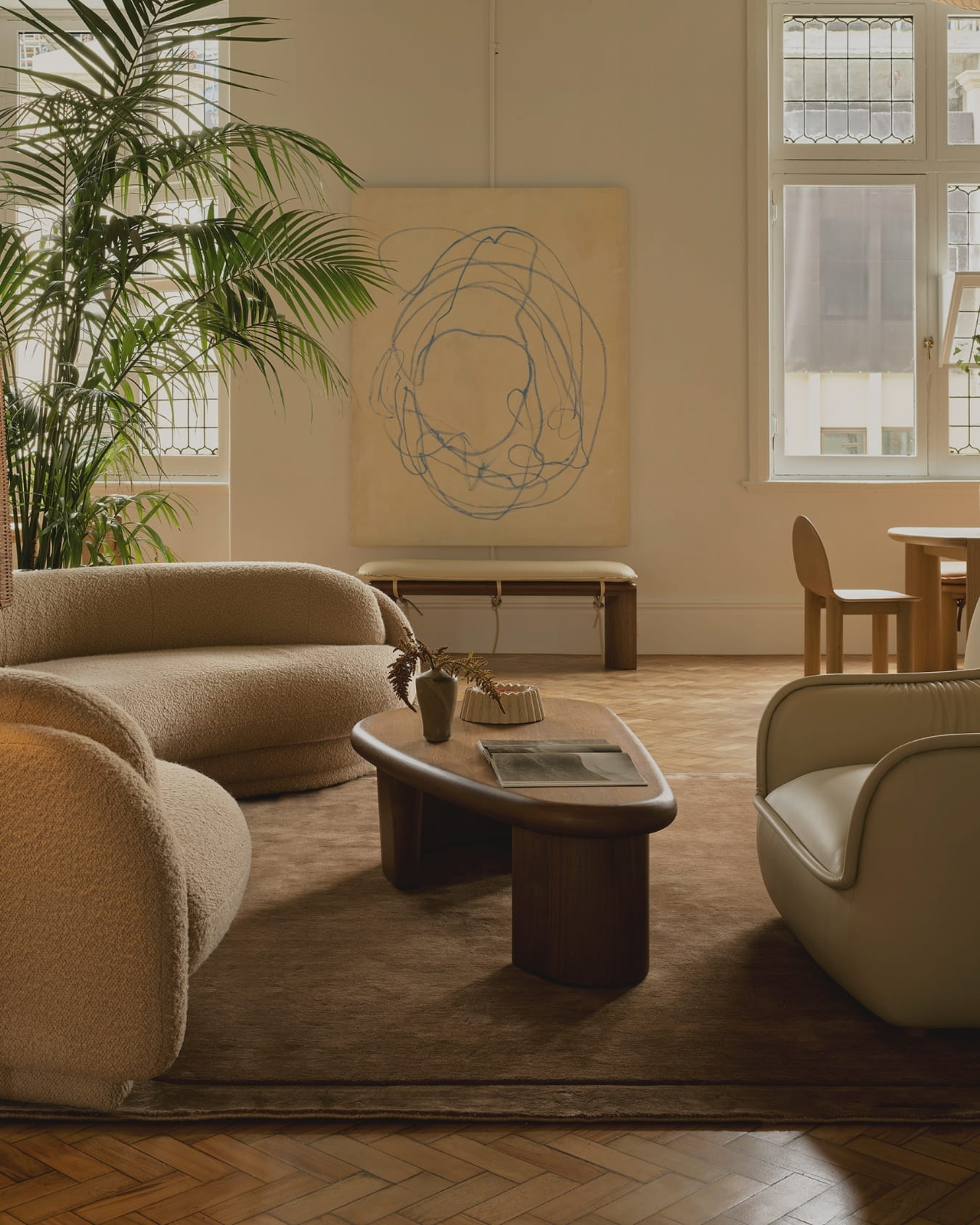 Modern living room with beige furniture, a coffee table, and a plant.