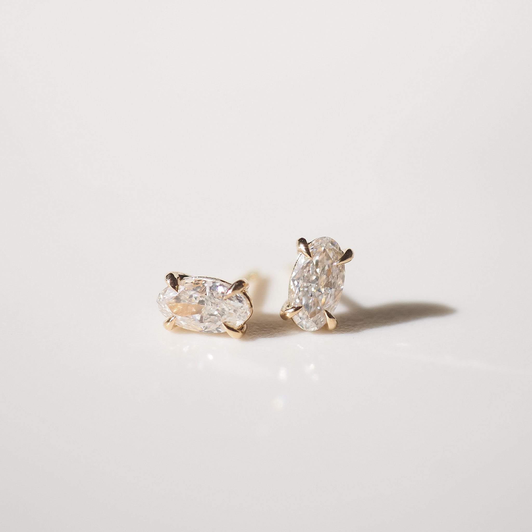 Pair of moval diamond stud earrings on a light gray background