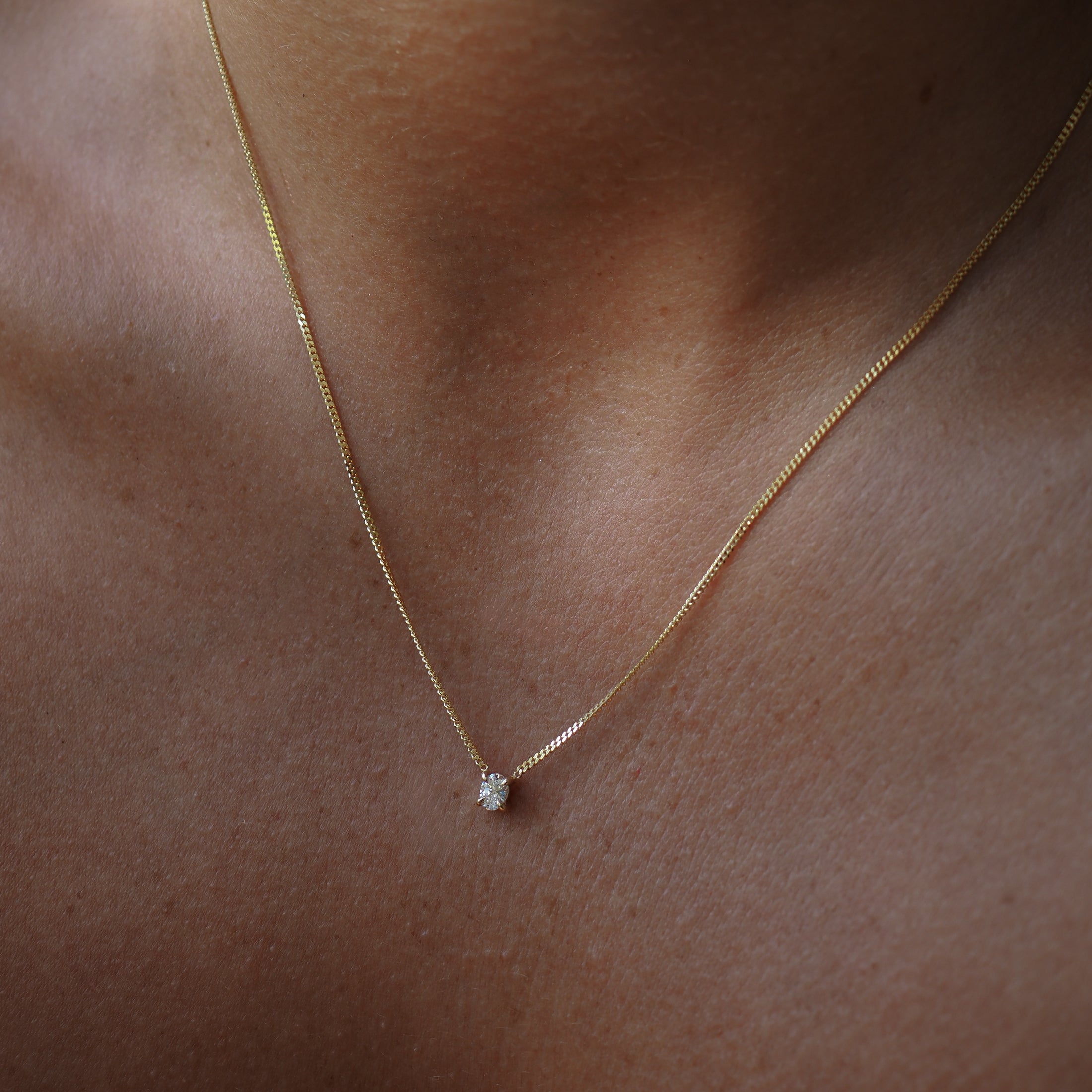 Oval lab-grown diamond necklace, handset within four claws and featured on yellow gold chain. 